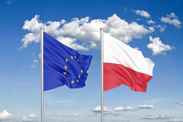 Polska i Unia Europejska dwie flagi na masztach i niebieskie zachmurzone niebo tło