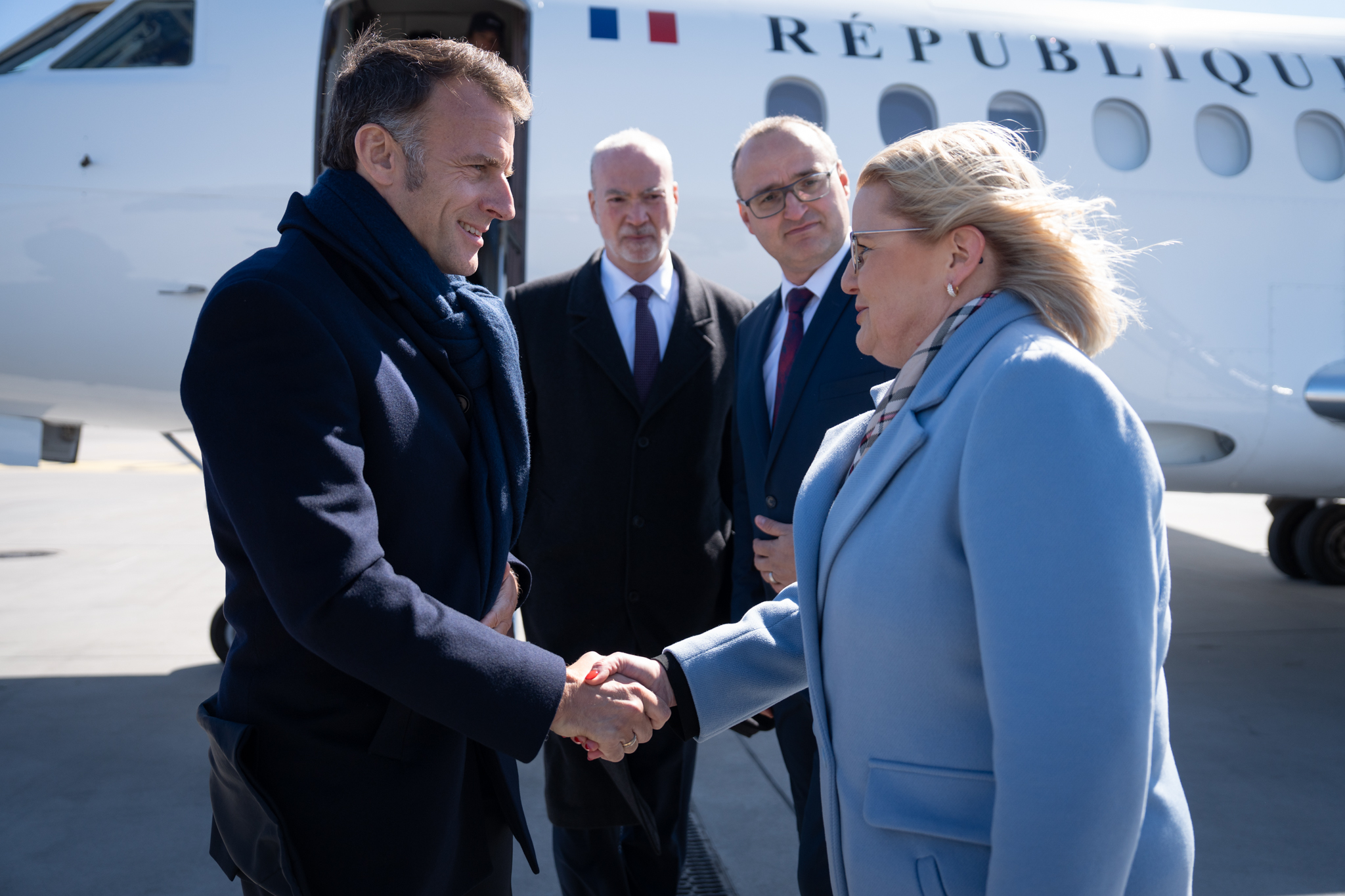 Fotografia przedstawiająca Agnieszkę Baranowską - członkinię zarządu województwa pomorskiego witającą na lotnisku Prezydenta Francji Emmanuela Macrona
